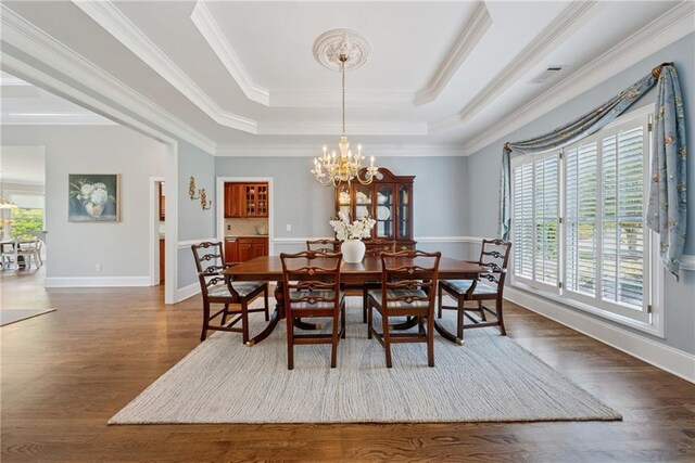 4790 Hyde Rd, Cumming, GA 30040 - dining room featuring a notable chandelier, dark wood-type flooring, a raised ceiling, and a healthy amount of sunlight
