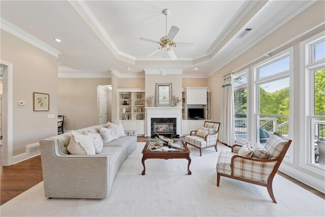 4790 Hyde Rd, Cumming, GA 30040 - living area featuring visible vents, a premium fireplace, wood finished floors, ceiling fan, and crown molding