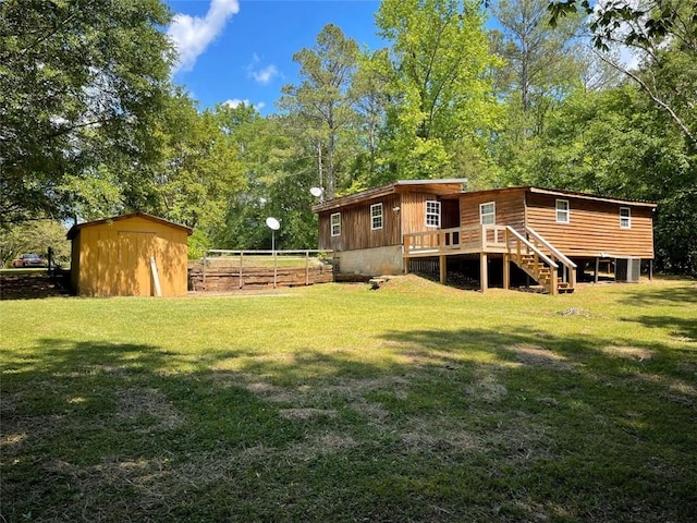 back of property with a lawn, stairs, and a wooden deck