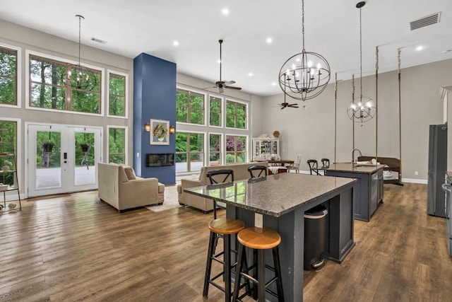 659 Creek Nation Rd, Jefferson, GA 30549 - kitchen featuring a chandelier, an island with sink, a ceiling fan, a high ceiling, and a kitchen bar