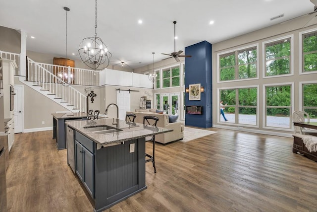 659 Creek Nation Rd, Jefferson, GA 30549 - kitchen featuring an island with sink, open floor plan, a ceiling fan, a kitchen breakfast bar, and a towering ceiling