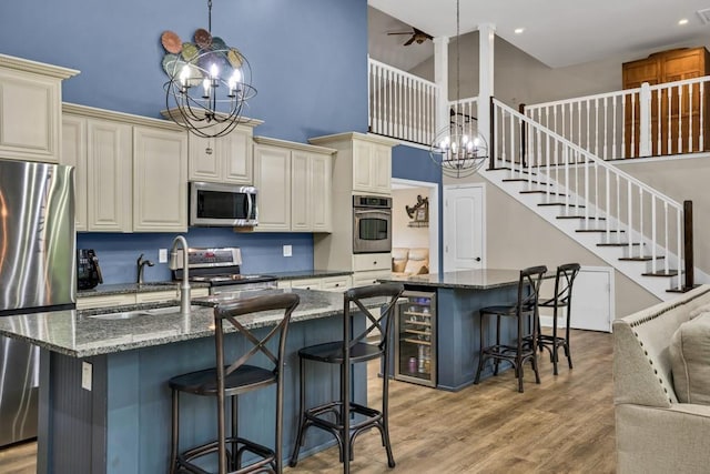 659 Creek Nation Rd, Jefferson, GA 30549 - kitchen featuring appliances with stainless steel finishes, a high ceiling, an island with sink, cream cabinets, and recessed lighting