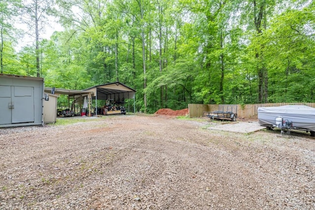 659 Creek Nation Rd, Jefferson, GA 30549 - view of yard featuring a carport, a shed, a view of trees, and dirt driveway