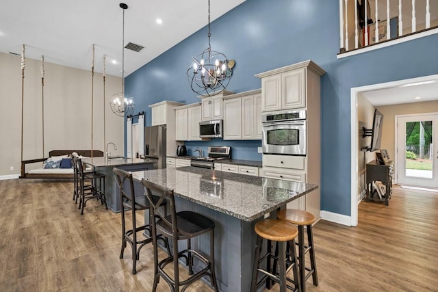 659 Creek Nation Rd, Jefferson, GA 30549 - kitchen with appliances with stainless steel finishes, a center island with sink, a high ceiling, a chandelier, and a breakfast bar