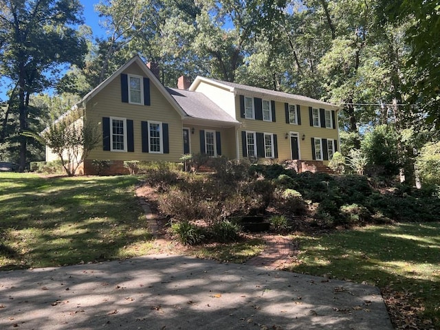 colonial home featuring a front lawn