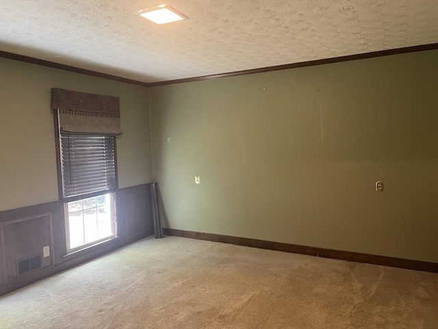carpeted spare room with crown molding and a textured ceiling