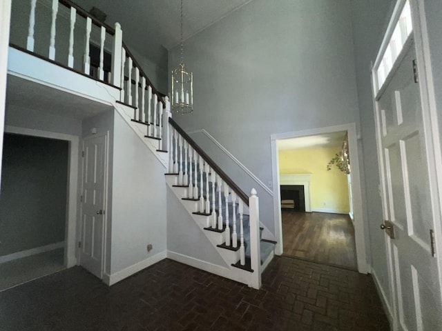 stairway with a chandelier and a towering ceiling