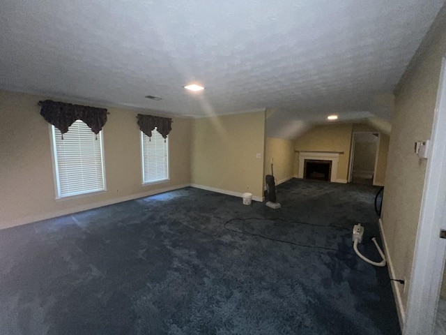 unfurnished living room featuring a textured ceiling, carpet, and vaulted ceiling