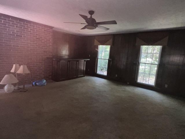 unfurnished living room featuring ceiling fan and carpet