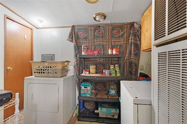 laundry room featuring washer and dryer, cabinets, and a textured ceiling