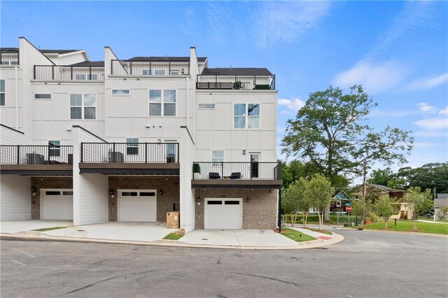 2535 Astaire Ct, Atlanta, GA 30318 - rear view of property featuring an attached garage, brick siding, and driveway