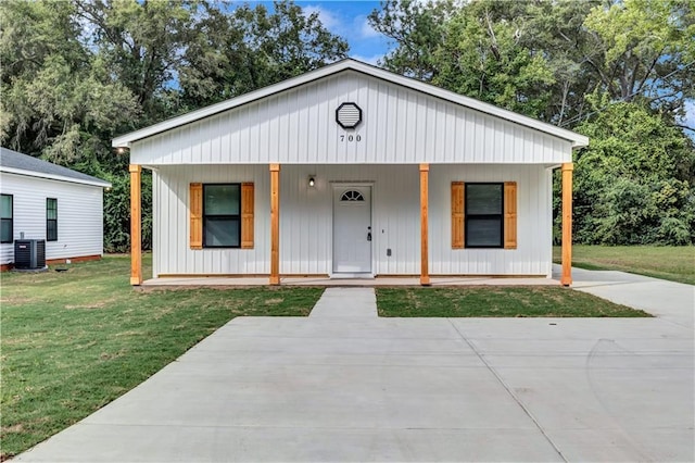 modern inspired farmhouse featuring central AC unit, covered porch, and a front lawn