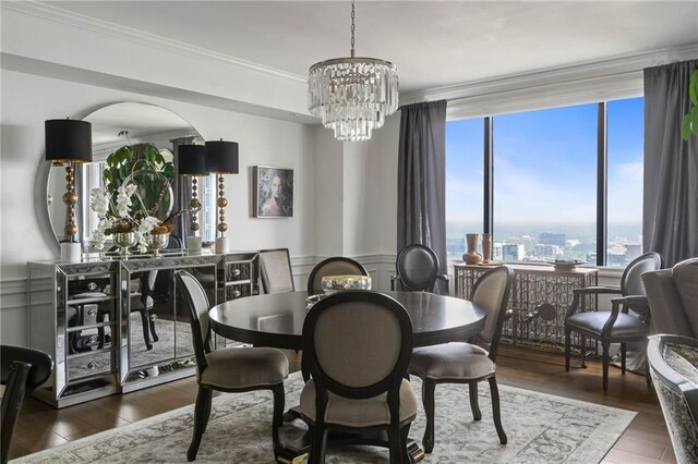 dining area with crown molding, dark hardwood / wood-style flooring, and a notable chandelier