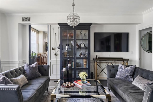 living room featuring a notable chandelier, crown molding, and dark wood-type flooring