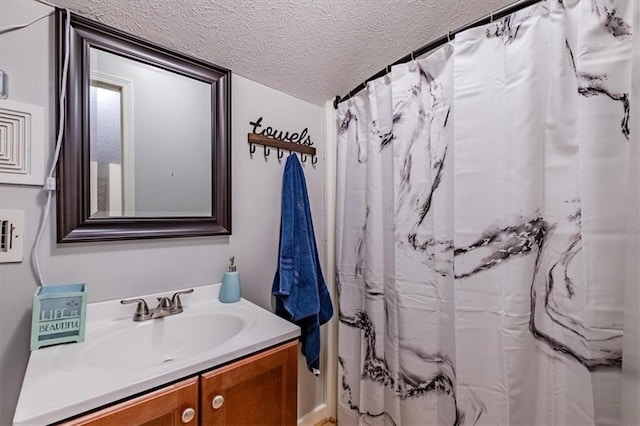 bathroom featuring vanity, a shower with shower curtain, and a textured ceiling