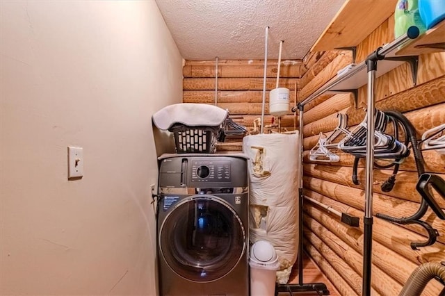 clothes washing area with washer / clothes dryer and a textured ceiling