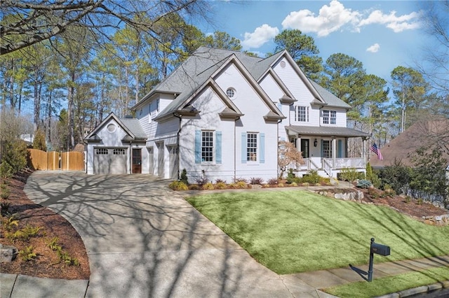 view of front of home with a garage, covered porch, and a front yard