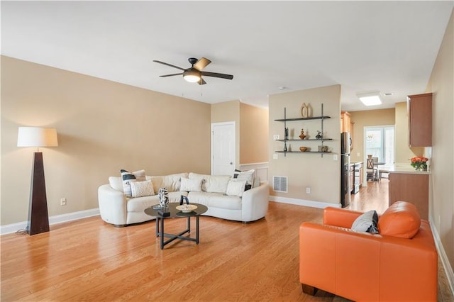 living room featuring ceiling fan and light hardwood / wood-style flooring