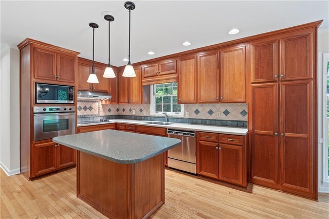 870 Richmond Hill Dr, Marietta, GA 30068 - kitchen with appliances with stainless steel finishes, a sink, under cabinet range hood, light wood-type flooring, and brown cabinetry