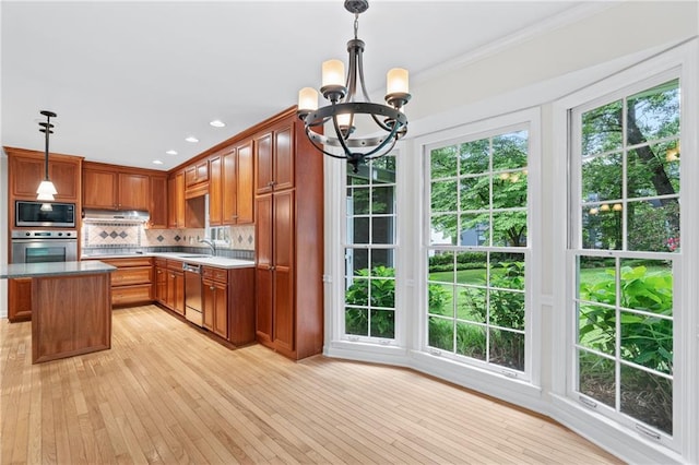 870 Richmond Hill Dr, Marietta, GA 30068 - kitchen featuring appliances with stainless steel finishes, under cabinet range hood, a chandelier, backsplash, and crown molding