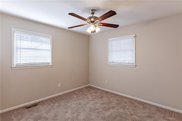 carpeted empty room featuring ceiling fan and plenty of natural light