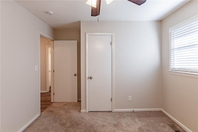 unfurnished bedroom featuring ceiling fan and light carpet