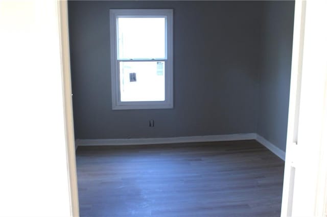 unfurnished room with dark wood-type flooring