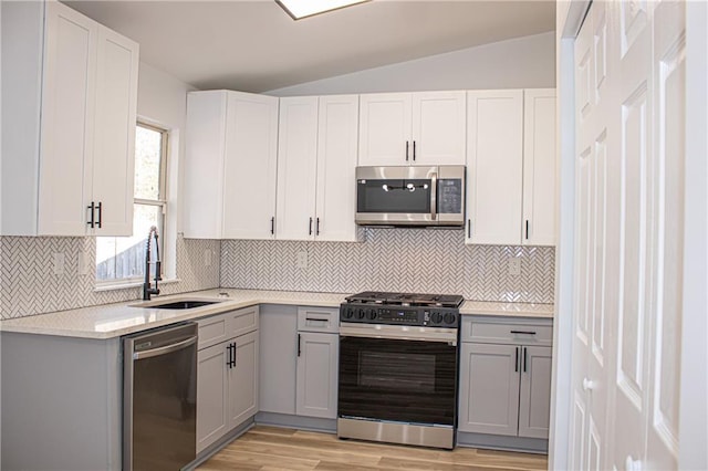 kitchen with a sink, stainless steel appliances, and gray cabinetry