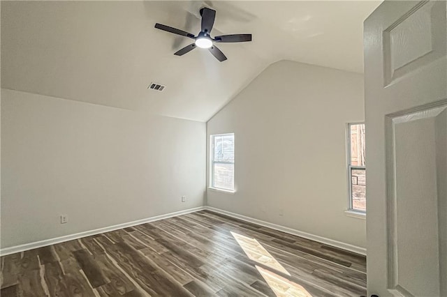 empty room with a wealth of natural light, visible vents, dark wood-type flooring, and ceiling fan