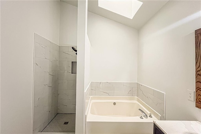 full bath featuring vanity, lofted ceiling with skylight, a bath, and tiled shower