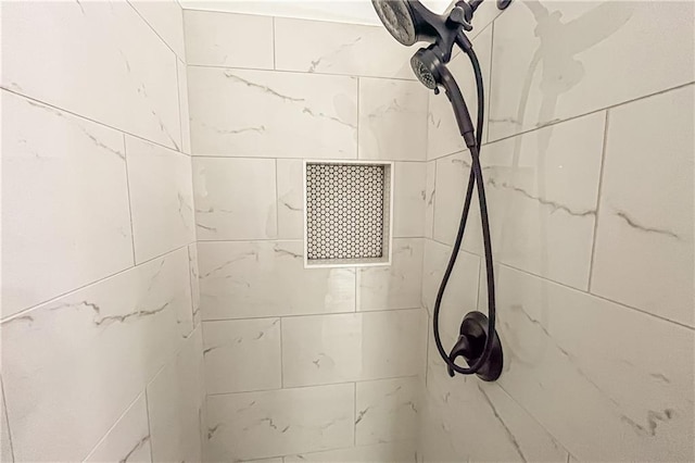 interior details featuring tiled shower