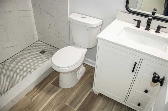 full bathroom featuring a shower stall, toilet, vanity, and wood finished floors