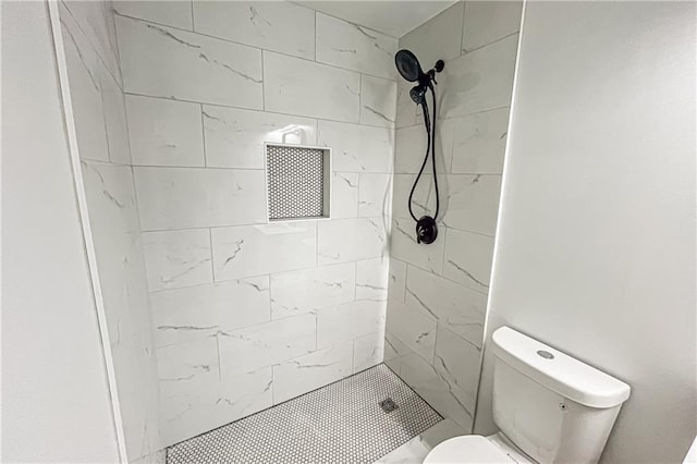 bathroom featuring toilet and a shower stall