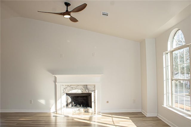 unfurnished living room featuring visible vents, baseboards, ceiling fan, lofted ceiling, and wood finished floors