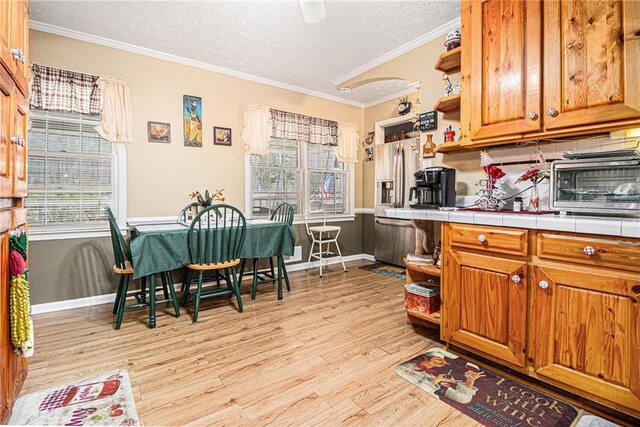 living room featuring light wood-type flooring, ceiling fan, and ornamental molding