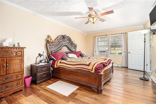 bedroom with ceiling fan, dark hardwood / wood-style floors, a textured ceiling, a closet, and ornamental molding