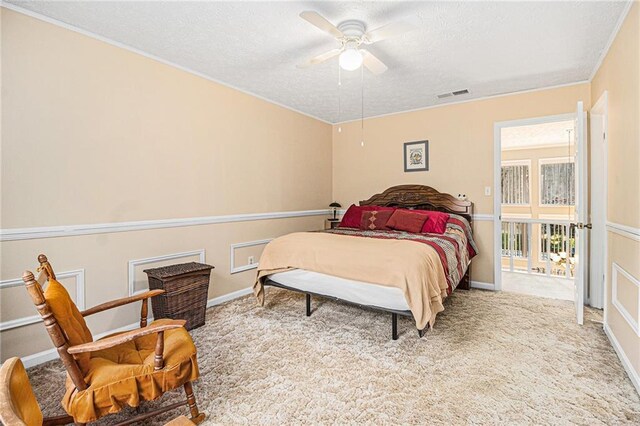 carpeted bedroom with ceiling fan and a textured ceiling