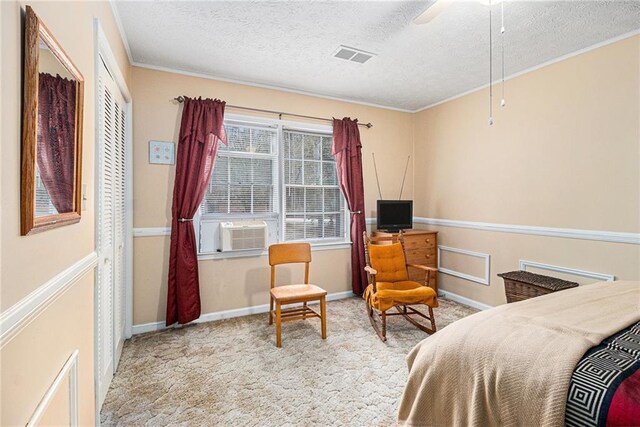 bedroom with ornamental molding, ceiling fan, light colored carpet, and a textured ceiling