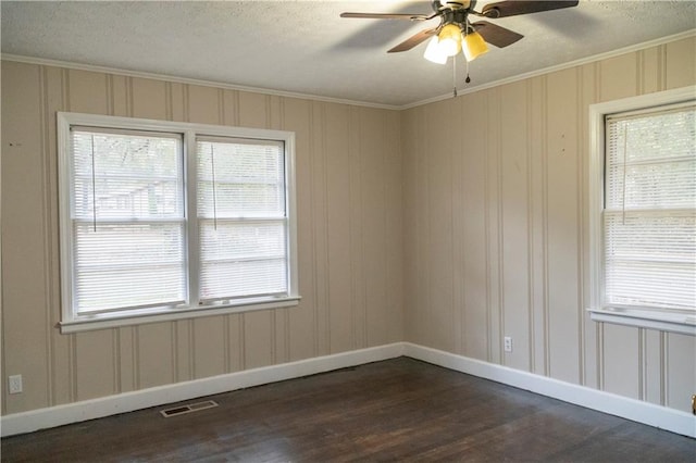 empty room featuring ornamental molding, a textured ceiling, ceiling fan, and dark wood-type flooring