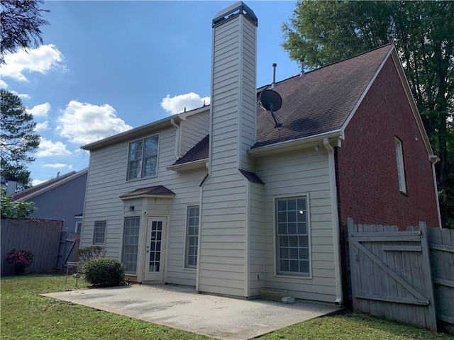 back of house with a patio area and a lawn