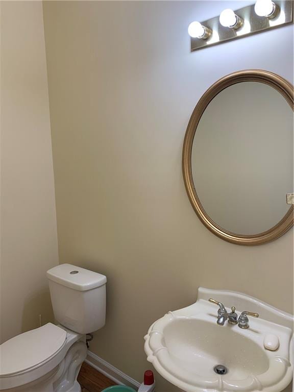 bathroom with toilet, hardwood / wood-style flooring, and sink