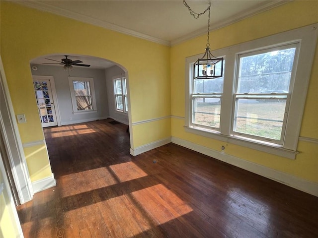 unfurnished dining area with dark hardwood / wood-style flooring, crown molding, and ceiling fan