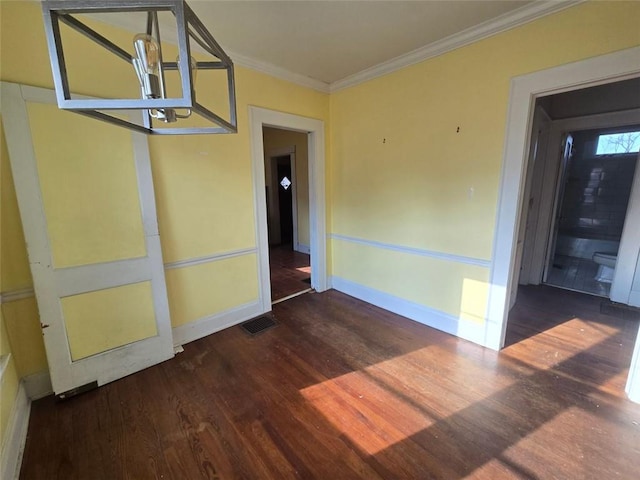 spare room with an inviting chandelier, ornamental molding, and dark hardwood / wood-style floors