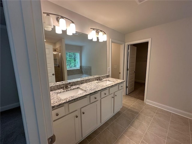 2180 Highridge Point Dr, Lithia Springs, GA 30122 - bathroom featuring double vanity, a spacious closet, a bath, a shower stall, and tile patterned flooring