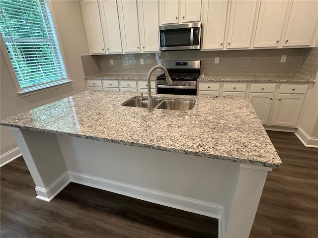 2180 Highridge Point Dr, Lithia Springs, GA 30122 - kitchen featuring appliances with stainless steel finishes, a sink, dark wood-style flooring, and baseboards