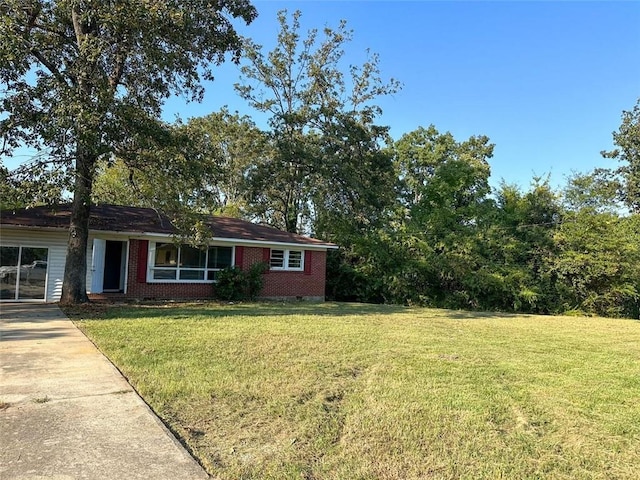 view of front of property with concrete driveway, brick siding, and a front yard