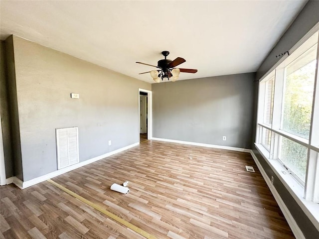 unfurnished room featuring visible vents, baseboards, and wood finished floors