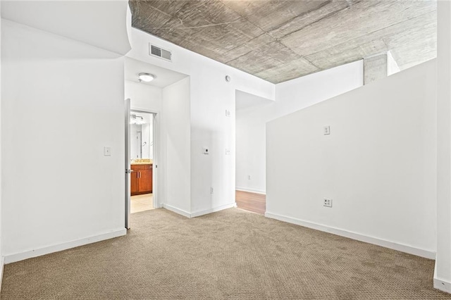 unfurnished room with carpet and baseboards