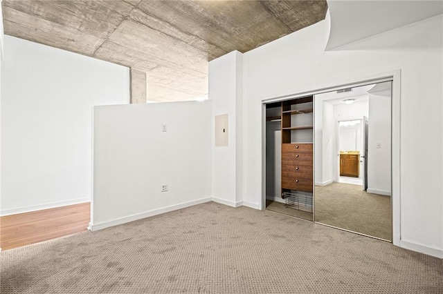 unfurnished bedroom featuring carpet, a closet, and baseboards