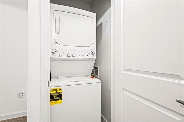 laundry room featuring stacked washing machine and dryer and baseboards